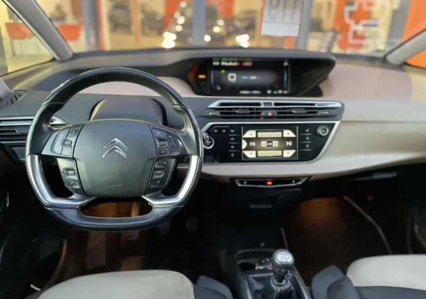 Intérieur du Citroën C4 Picasso 2014 avec volant multifonction, tableau de bord moderne et levier de vitesse manuel.