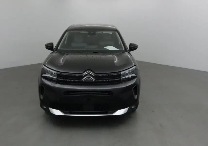 Vue frontale d'un Citroën C5 Aircross noir 2024 avec capot légèrement mouillé et calandre distinctive double chevron.