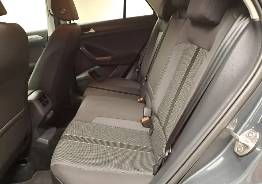 Vue intérieure côté droit des sièges arrière du Volkswagen T-Roc 1.5 TSI 150 DSG7 LIFE en gris Indium, tissu bicolore.