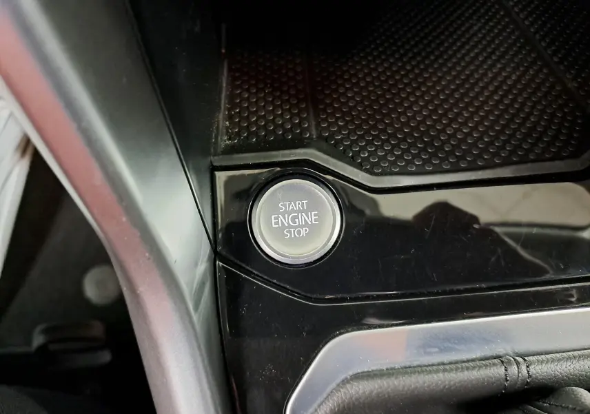 Gros plan sur le bouton Start Engine Stop entouré de la console noire brillante du Volkswagen T-Roc 2024.