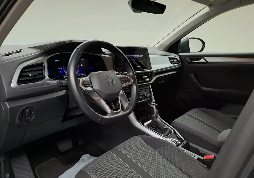 Intérieur avant droit du Volkswagen T-Roc 1.5 TSI 2024 avec tableau de bord numérique et volant multifonction noir.