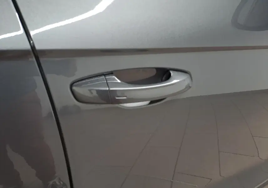 Poignée de porte côté gauche du Volkswagen T-Roc 2024 en gris Indium métallisé avec reflet intérieur.