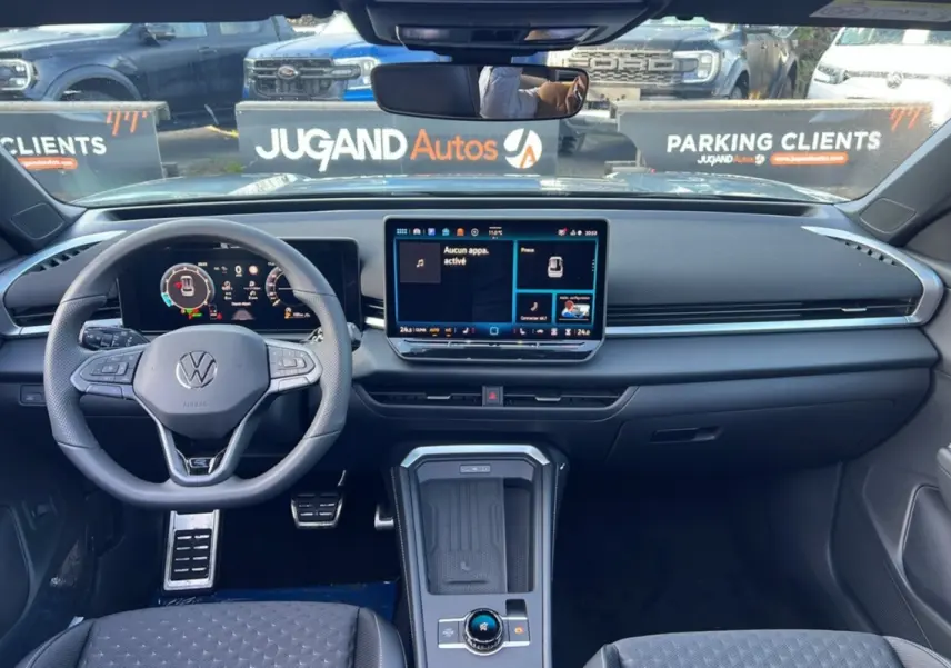 Vue intérieure frontale du Volkswagen T-Roc 2026, tableau de bord moderne avec écran tactile et volant multifonctions cuir.