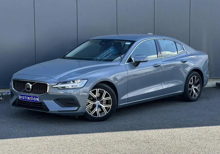 Volvo S60 gris Thunder en 3/4 avant droit, avec jantes alliage 17 pouces et contours de fenêtres chromés.