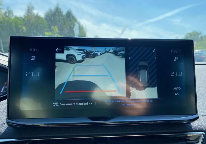 Écran tactile intérieur affichant la caméra de recul et la vue 360° du Peugeot 3008 gris platinium en stationnement.