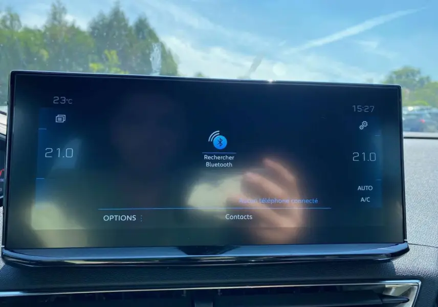 Écran tactile 10 pouces du Peugeot 3008 2023 affichant la recherche Bluetooth, avec tableau de bord carbone visible.