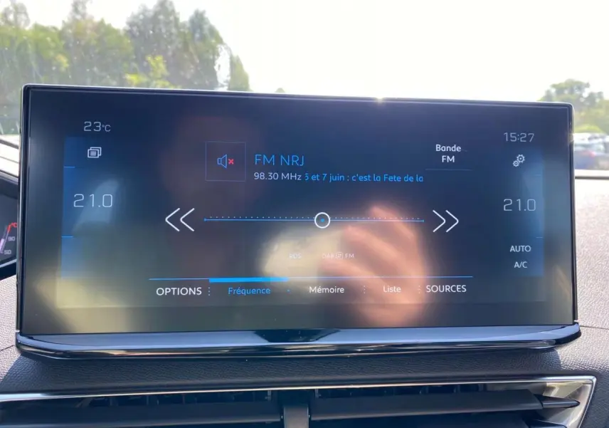 Écran tactile 10 pouces du Peugeot 3008 gris platinium affichant la radio FM NRJ et la température intérieure.