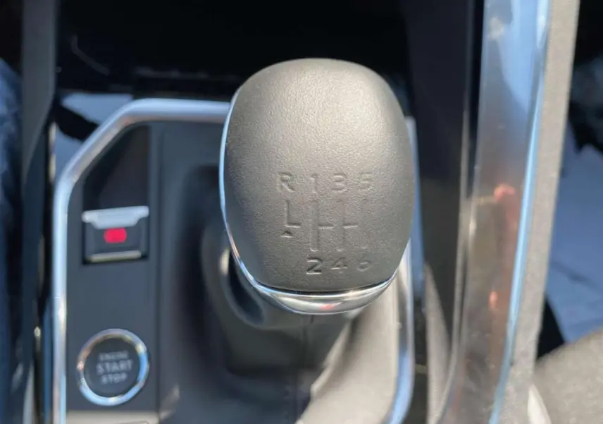 Le levier de vitesses manuel noir du Peugeot 3008 2023, vue rapprochée de la console centrale.