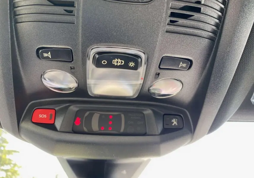 Vue en gros plan du plafonnier avec boutons SOS et éclairage du Peugeot 3008 gris platinium 2023.