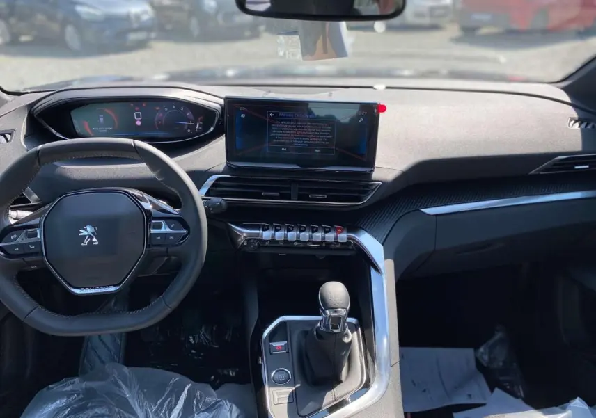 Intérieur Peugeot 3008 2023 vu de face, tableau de bord moderne avec écran tactile 10" et volant compact multifonctions.