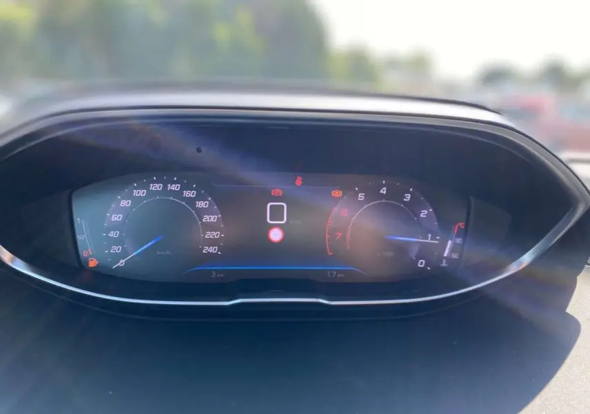 Tableau de bord numérique Peugeot 3008 2023 affichant la vitesse et le régime moteur au soleil.