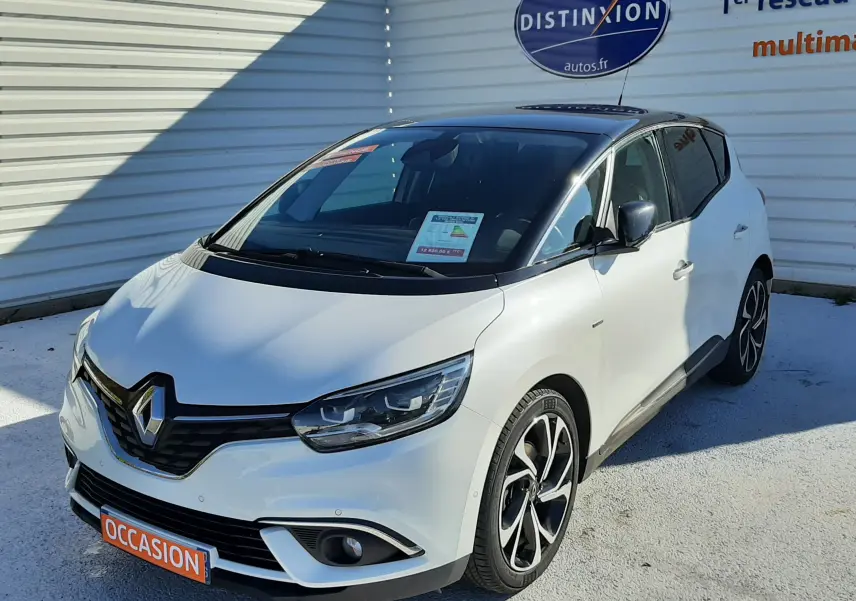 Renault Scénic IV blanc nacré avec toit noir, vue 3/4 avant droit, jantes alliage et calandre chromée visible.