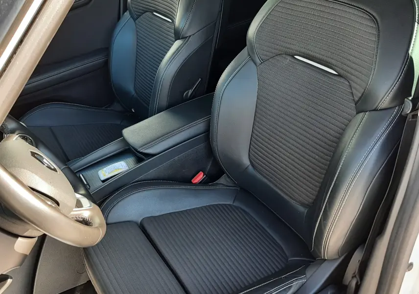 Vue intérieure rapprochée des sièges avant noirs en tissu et cuir du Renault Scenic IV blanc nacré avec toit noir.