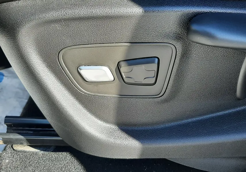 Commandes électriques de réglage du siège en gros plan sur un Renault Scenic IV blanc nacré.