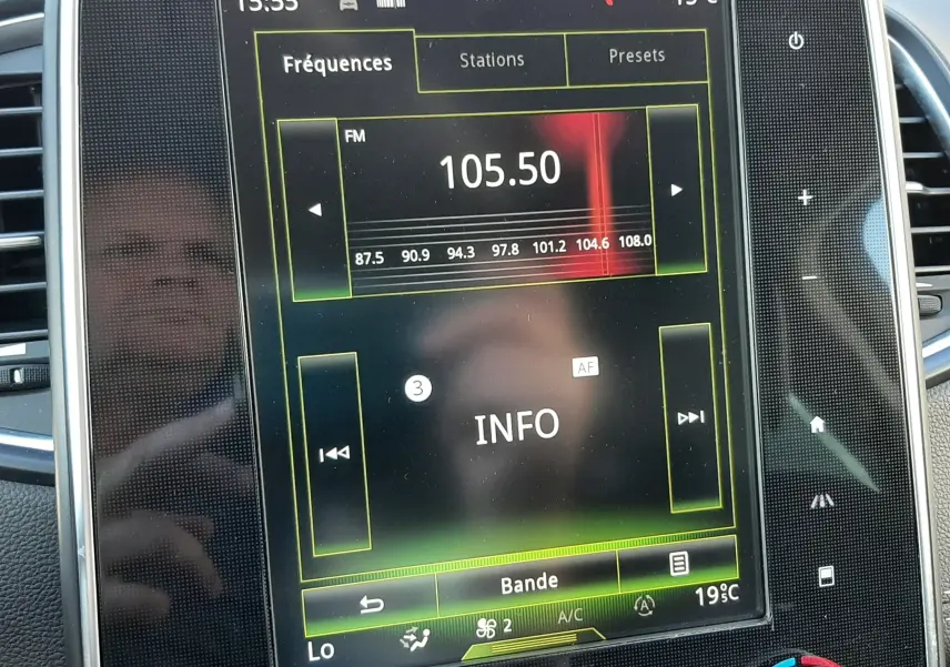 Écran tactile central du système multimédia Renault Scenic IV affichant la radio FM sur 105.50 MHz avec commandes climatisation visibles.