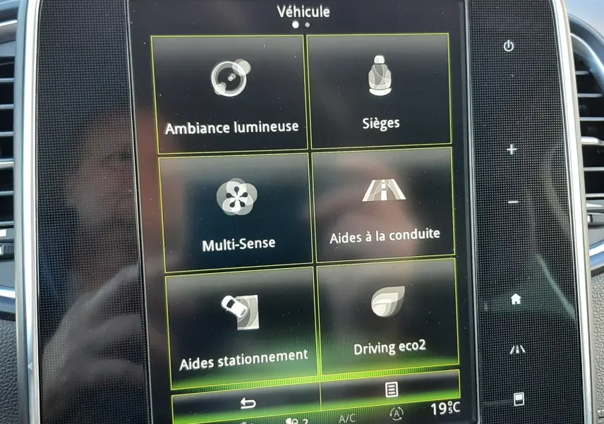 Écran tactile central du Renault Scenic IV 2018 montrant les options véhicule avec interface noire et boutons latéraux.