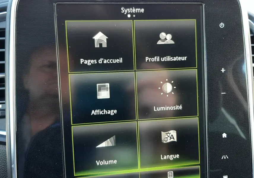 Écran tactile central du Renault Scénic IV affichant le menu système avec options de réglages et climatisation.