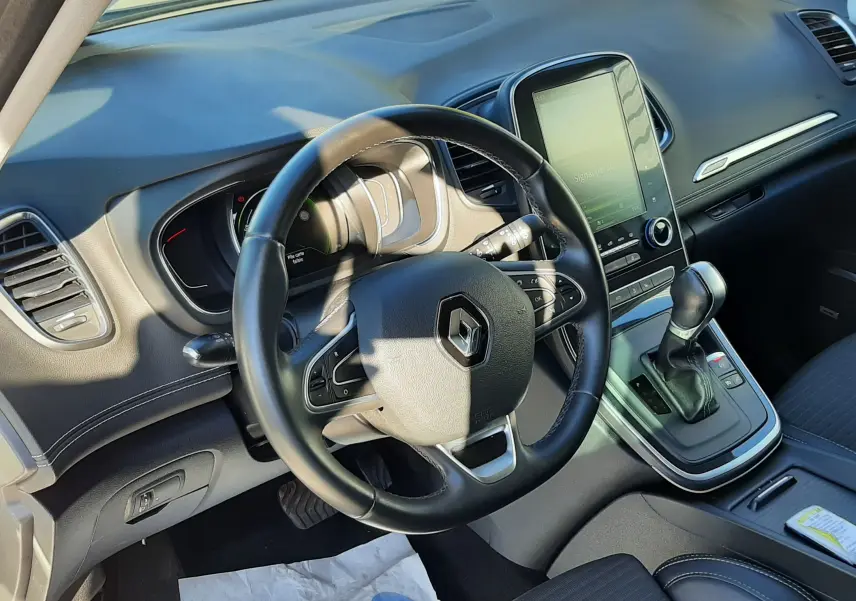Intérieur du Renault Scénic IV essence 2018, vue côté conducteur sur volant cuir, tableau de bord et écran tactile central.