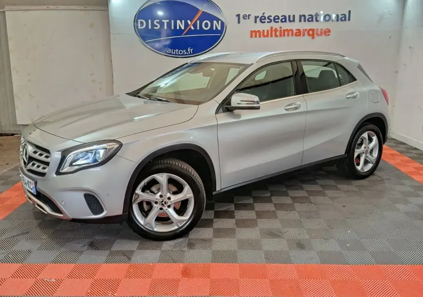 Mercedes GLA 200 d gris clair vue 3/4 avant droit, avec jantes alliage et feux LED allumés en intérieur showroom.