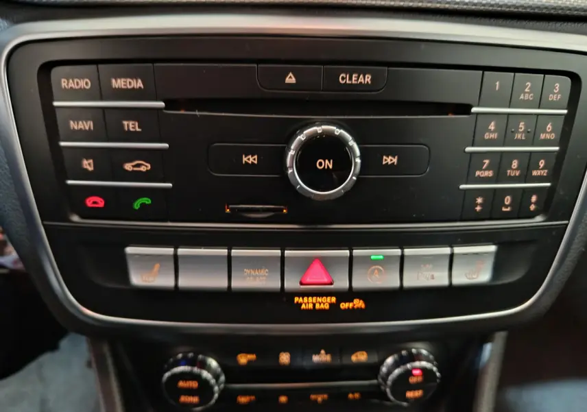 Gros plan sur la console centrale noire du Mercedes GLA 200 d Business Executive 2018 avec commandes multimédia et climatisation digitale.