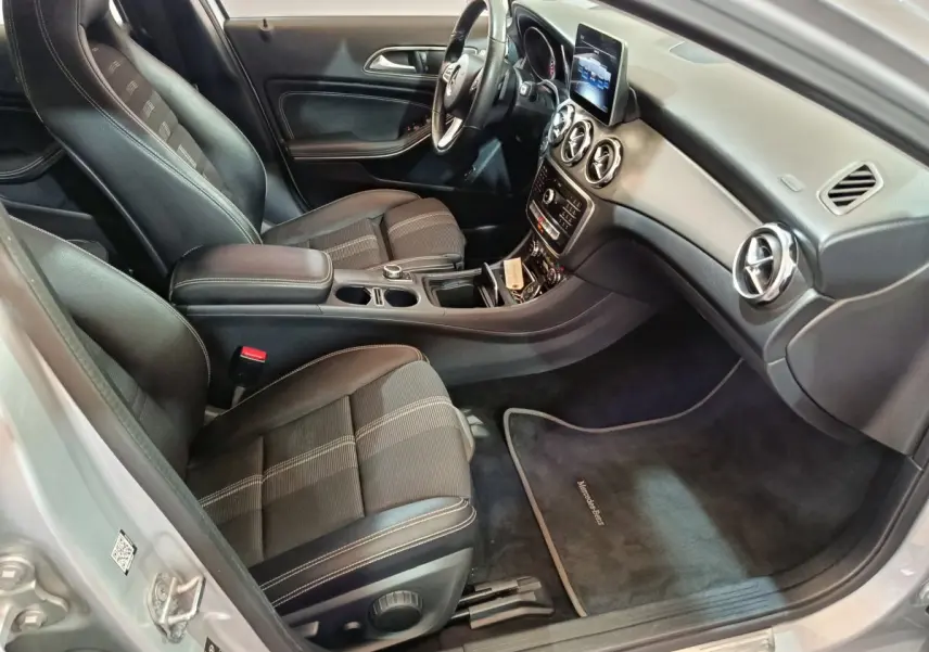 Vue intérieure côté passager du Mercedes GLA 200 d gris clair, avec sièges tissu noir et tableau de bord moderne.