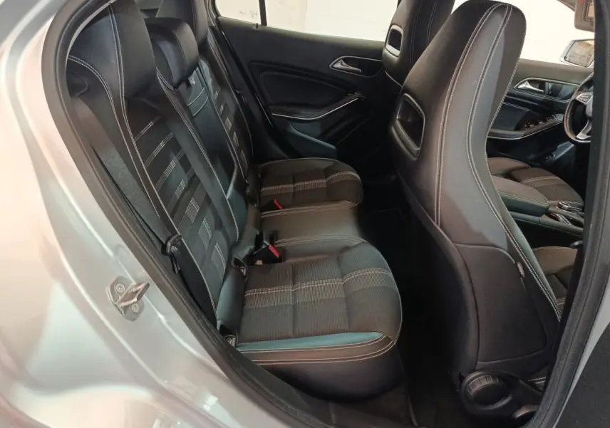 Vue côté gauche sur l'intérieur arrière noir avec sièges en tissu et cuir d'une Mercedes GLA 200 d gris clair 2018.