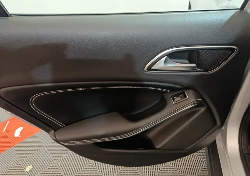 Gros plan sur la porte avant droite noire avec surpiqûres blanches d'un Mercedes GLA 200 d Business Executive 2018.