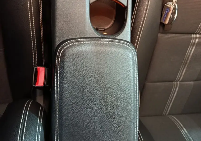 Vue rapprochée de la console centrale en cuir noir avec surpiqûres blanches et siège tissu gris du Mercedes GLA 200 d 2018.