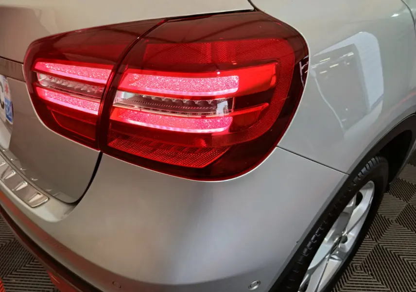 Feu arrière droit allumé sur Mercedes GLA 200 d gris clair, vue rapprochée du coin arrière droit avec jante visible.