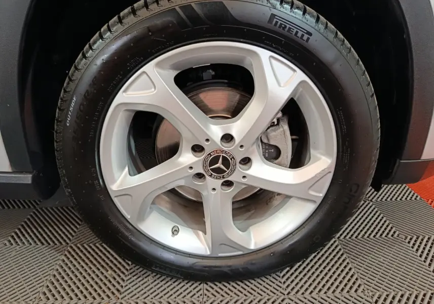 Gros plan sur la roue avant droite d'un Mercedes GLA 200 d gris clair avec jante alliage cinq branches et pneu Pirelli.