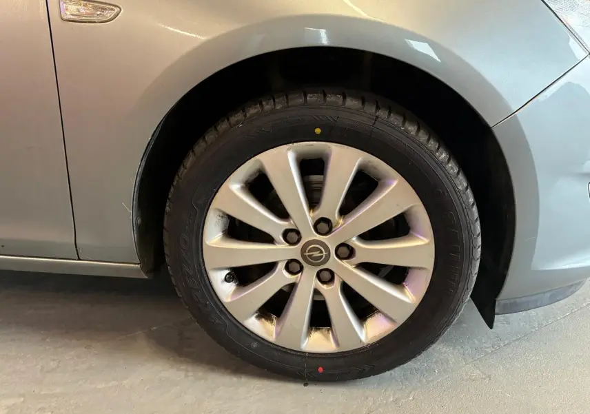 Gros plan sur la roue avant gauche gris métallisé d'une Opel Astra 1.6 CDTI 110 de 2015 avec jante alliage.