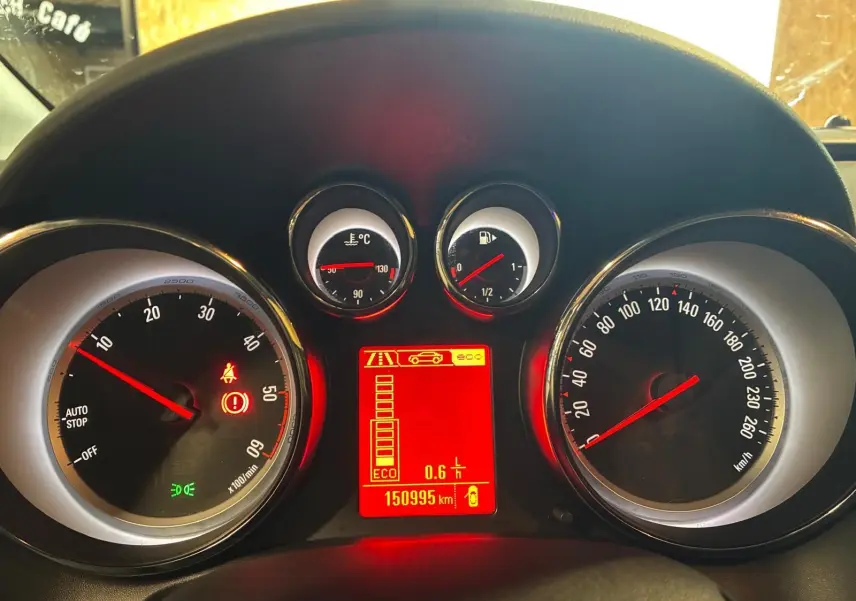 Tableau de bord d'Opel Astra 1.6 CDTI 2015 avec compte-tours, vitesse, jauges et écran central rouge allumé.