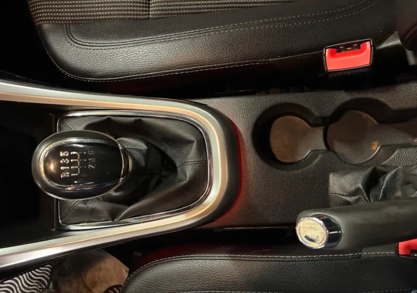 Vue rapprochée de la console centrale de l’Opel Astra gris, mettant en valeur le levier de vitesse manuel et le frein à main noir.