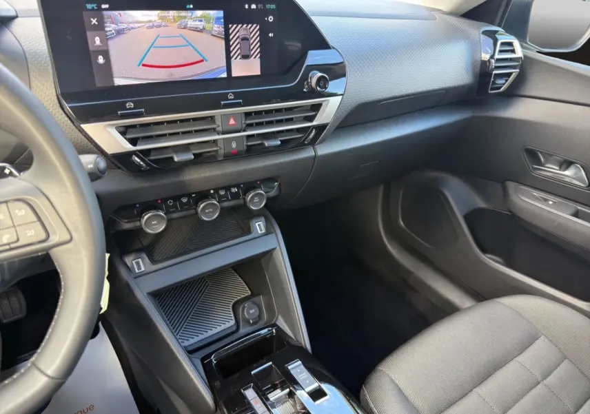 Vue intérieure côté passager de la Citroën C4 hybride 2025, avec écran tactile central affichant la caméra de recul.