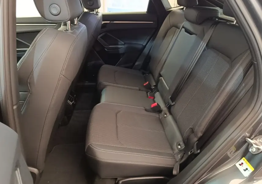 Vue intérieure côté droit des sièges arrière en tissu gris foncé de l'Audi Q3 Sportback 45 TFSI e 2024.