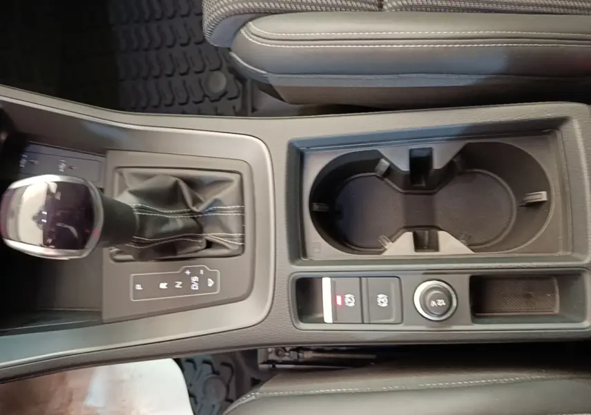 Vue rapprochée de la console centrale de l'Audi Q3 Sportback gris clair 2024 avec levier de vitesses et porte-gobelets.