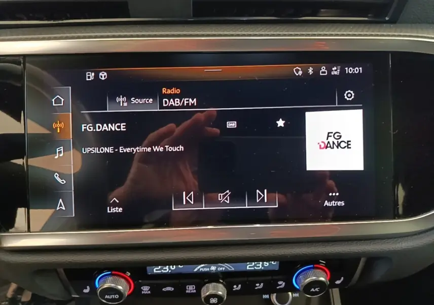 Écran tactile central de l’Audi Q3 Sportback 2024 affichant la radio DAB/FM, avec commandes climatisation en dessous.
