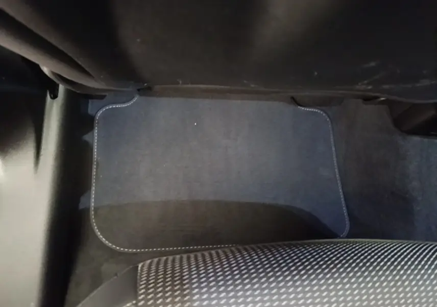 Détail de la moquette noire au sol côté passager arrière de l’Audi Q3 Sportback gris clair 2024.