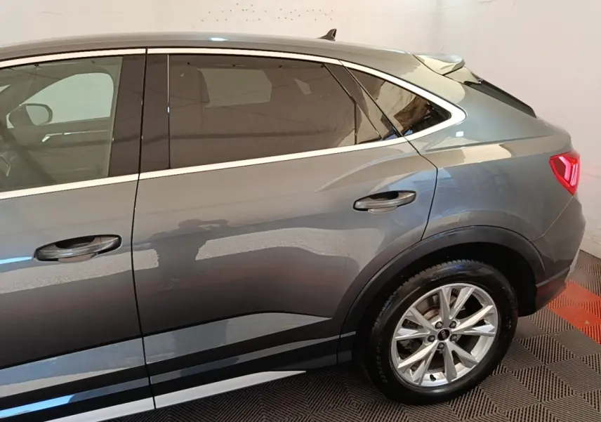 Vue latérale droite d'un Audi Q3 Sportback gris clair 2024 avec jantes alliage et vitres teintées.