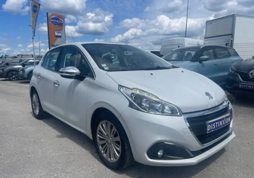 Peugeot 208 blanc perle en 3/4 avant droit avec jantes alliage et rétroviseurs chromés sur parking.