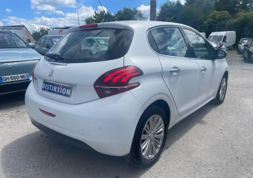Peugeot 208 blanc perle vue 3/4 arrière droit avec feux arrière distinctifs et jantes alliage titane.