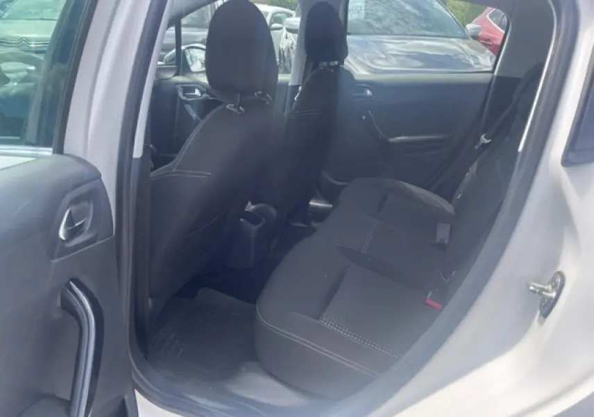 Vue intérieure côté gauche sur la banquette arrière noire d'une Peugeot 208 blanc perle texture 2018.