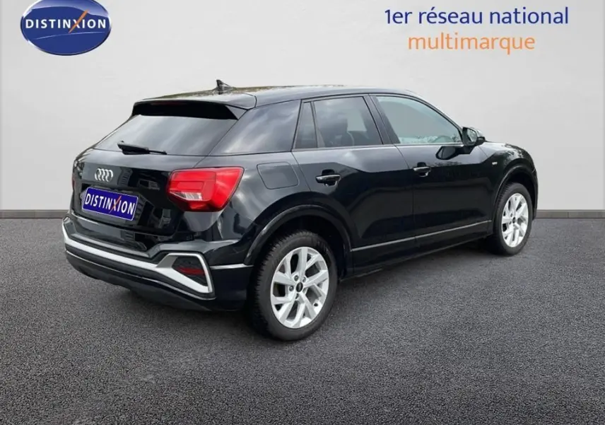 Audi Q2 noir mito metal vue 3/4 arrière droit, jantes argentées et feux arrière rouges bien visibles.