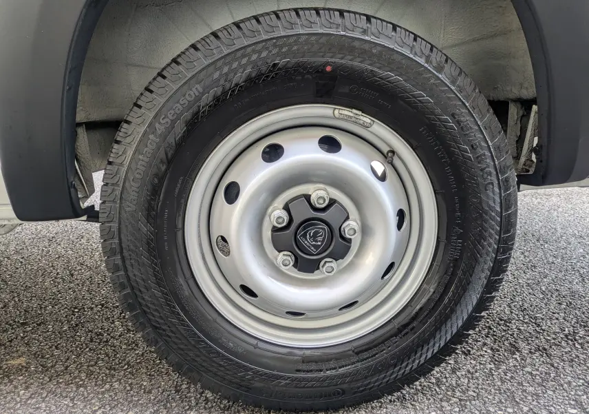 Gros plan sur la roue avant droite du Peugeot Boxer Fourgon blanc, jante acier 16 pouces avec pneu toutes saisons.