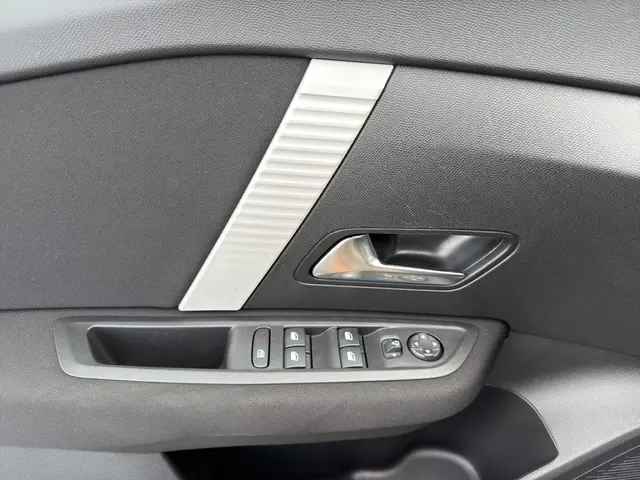 Détail intérieur de la porte côté conducteur de la Citroën C4 hybride bleue, avec commandes de vitres et rétroviseurs.