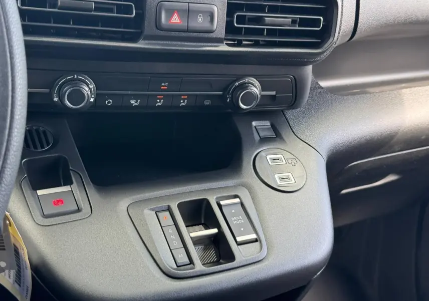 Détail de la console centrale noire du Citroën Berlingo Fourgon XL Diesel 130ch avec commandes de climatisation et boîte automatique.