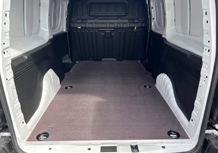 Vue intérieure arrière du Citroën Berlingo Fourgon XL blanc Icy, montrant l'espace de chargement vide avec revêtement au sol.