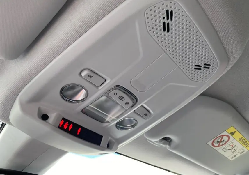 Vue en contre-plongée du plafonnier gris clair de l'Opel Corsa 2021 avec commandes d'éclairage et haut-parleur intégré.