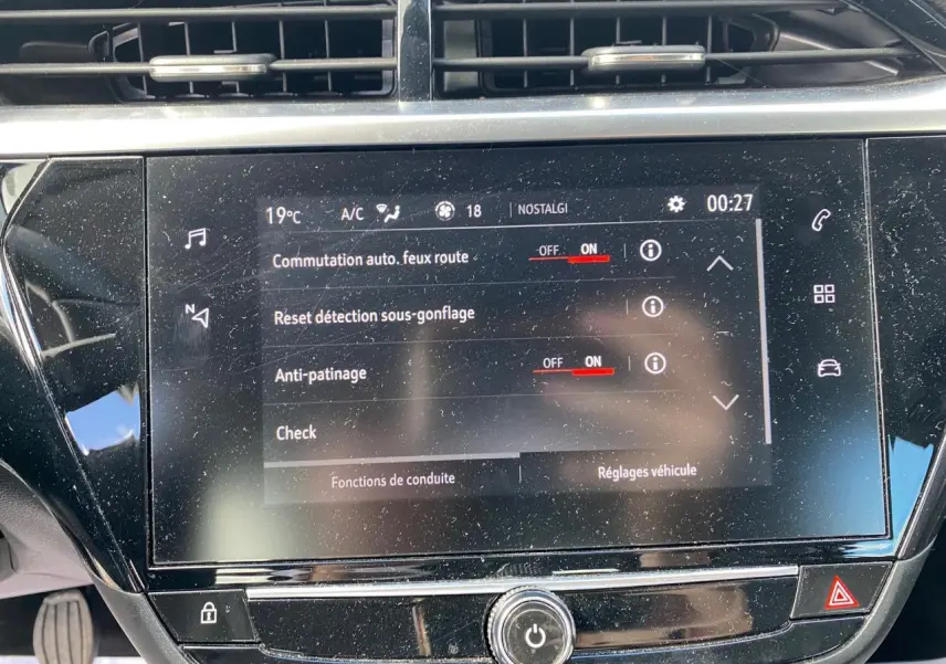 Vue rapprochée du tableau de bord de l'Opel Corsa bleu nautique, mettant en valeur l'écran digital tactile et les commandes tactiles latérales.