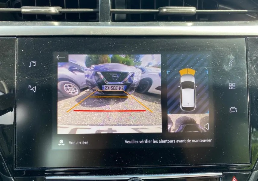 Écran digital de l'Opel Corsa bleu nautique montrant la caméra de recul avec vue arrière et aide au stationnement.